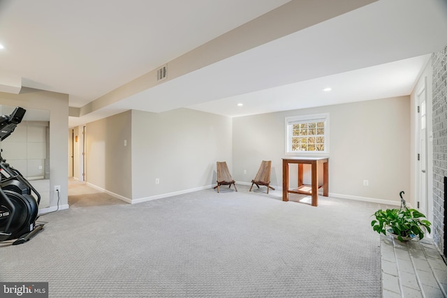 exercise room with a brick fireplace and light colored carpet