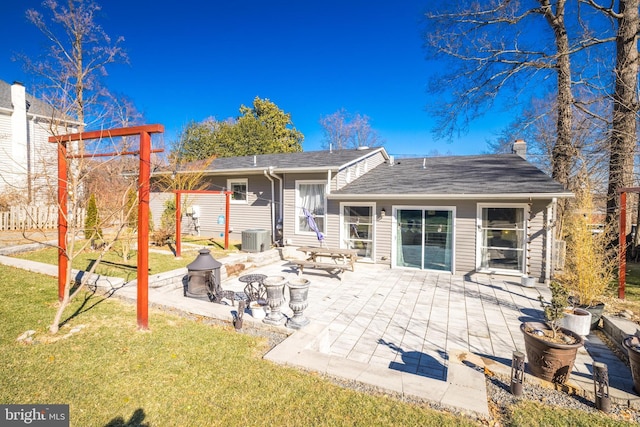 rear view of house with a patio area, central AC unit, and a lawn