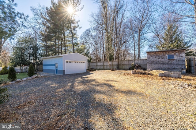 view of yard with a garage and an outbuilding