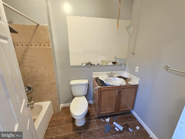 full bathroom featuring vanity, tiled shower / bath, and toilet