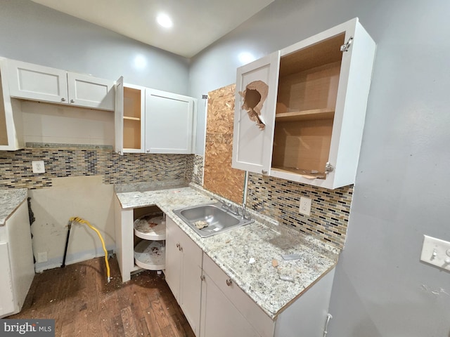 kitchen featuring dark hardwood / wood-style floors, tasteful backsplash, sink, white cabinets, and light stone countertops