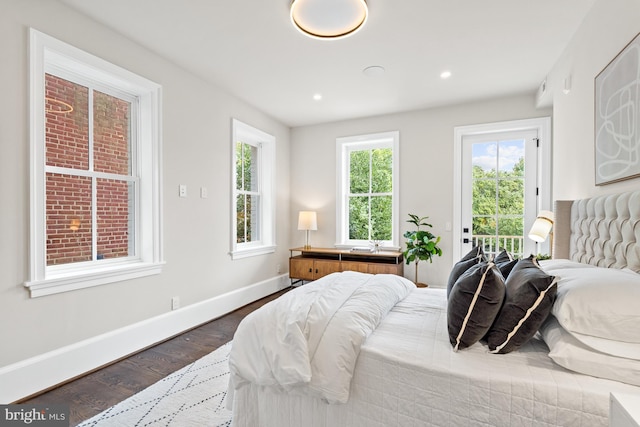 bedroom with dark hardwood / wood-style floors and access to exterior