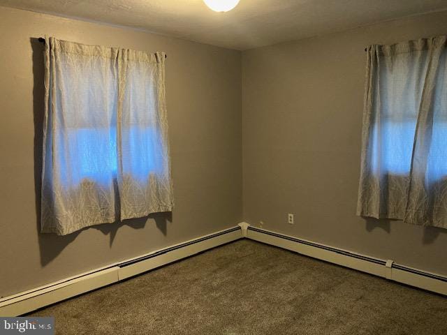 spare room featuring carpet and a baseboard radiator