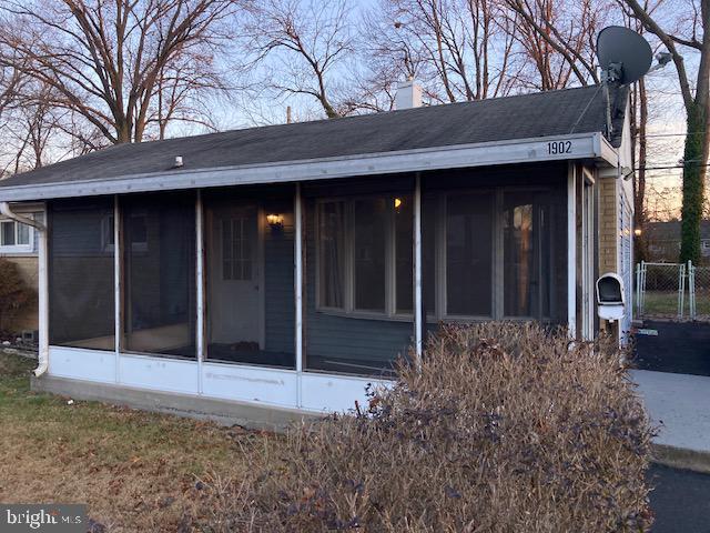 rear view of house featuring a sunroom