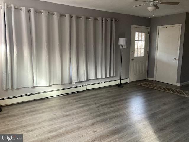 entryway featuring a baseboard heating unit, hardwood / wood-style flooring, and ceiling fan