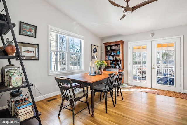 dining area with lofted ceiling, french doors, light wood-style flooring, and a wealth of natural light