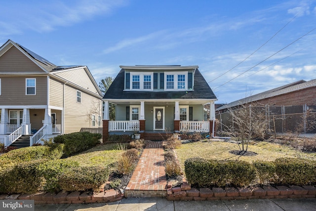 view of front of property with a porch and fence