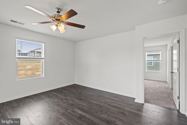 spare room featuring ceiling fan, plenty of natural light, and dark hardwood / wood-style flooring