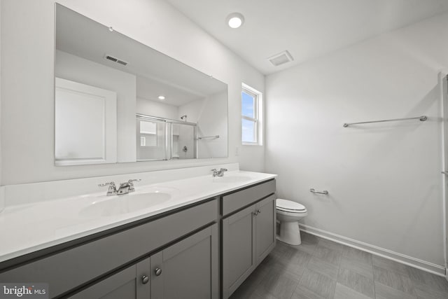 bathroom featuring vanity, toilet, and an enclosed shower