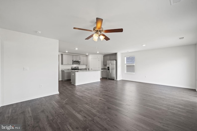 unfurnished living room featuring dark hardwood / wood-style floors and ceiling fan