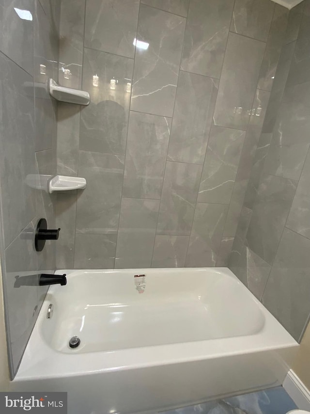 bathroom featuring tiled shower / bath and tile walls