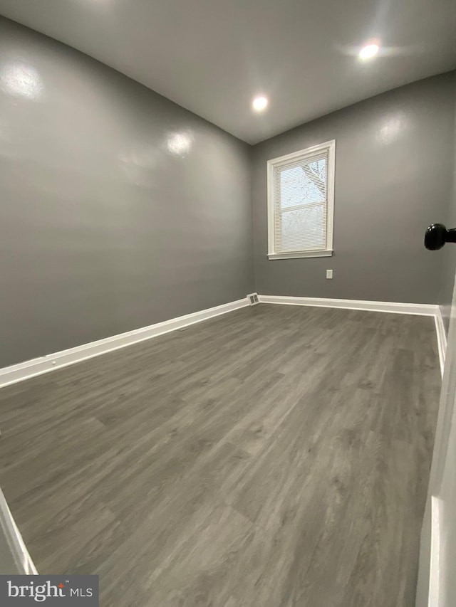 unfurnished room featuring dark wood-type flooring