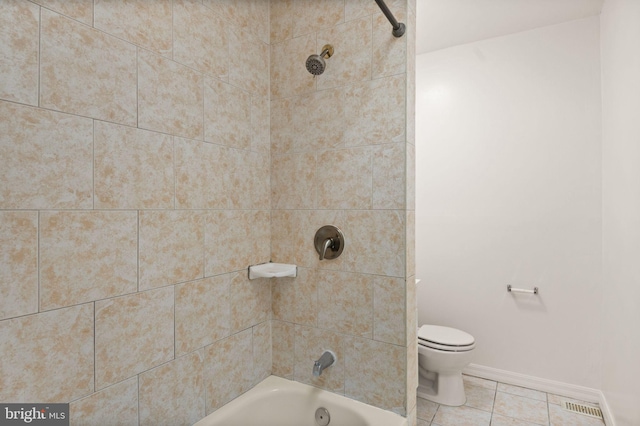 bathroom with tiled shower / bath, tile patterned floors, and toilet