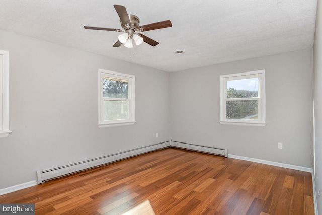 unfurnished room with hardwood / wood-style flooring, a wealth of natural light, and baseboard heating