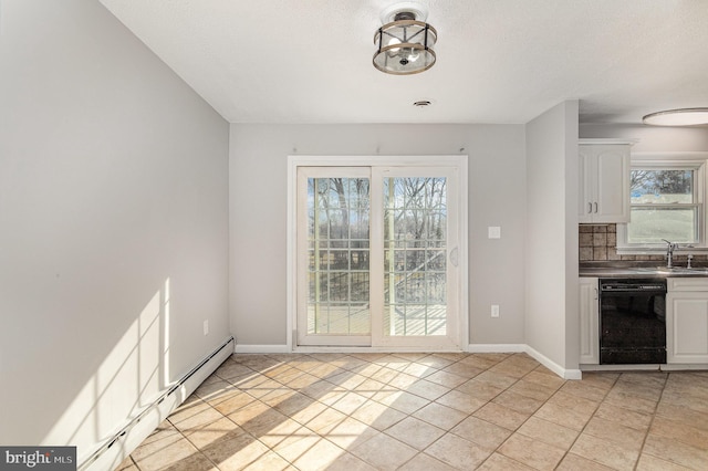 unfurnished dining area with a baseboard radiator, a textured ceiling, and light tile patterned floors