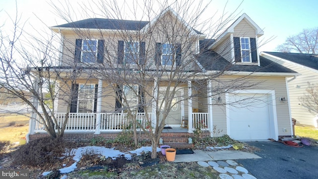 view of front of property featuring a garage, covered porch, and roof with shingles