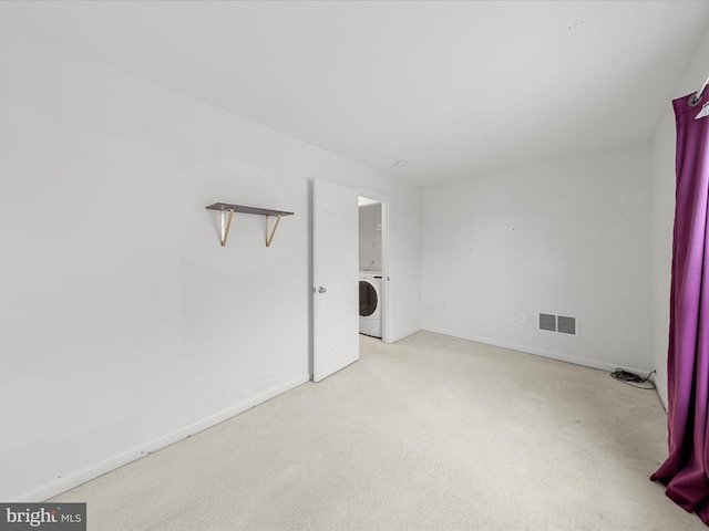 laundry area featuring washer / clothes dryer, light colored carpet, visible vents, laundry area, and baseboards