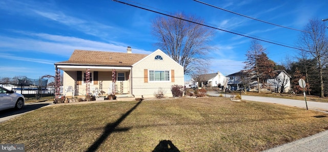 bungalow-style home with a porch, a front yard, and a trampoline