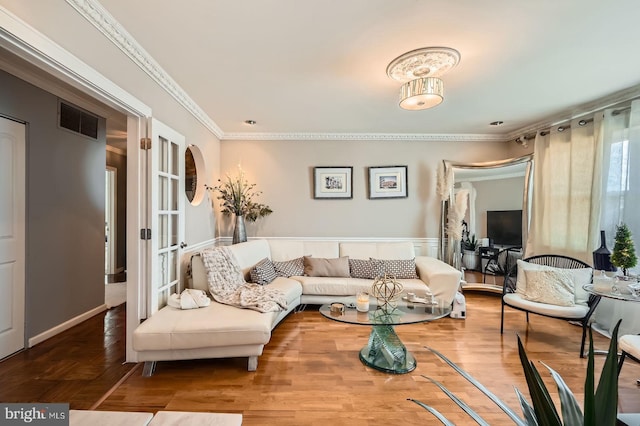 living area with visible vents, french doors, wood finished floors, and ornamental molding