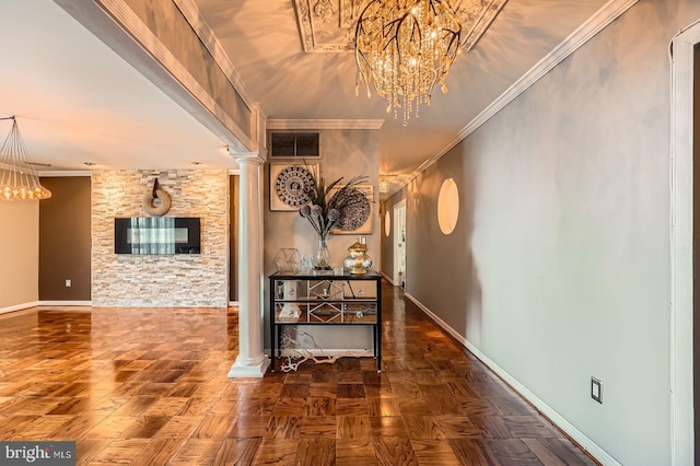 hall featuring visible vents, crown molding, baseboards, a chandelier, and ornate columns