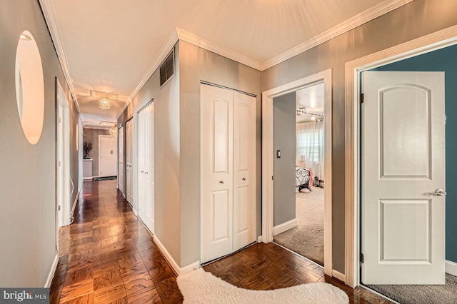 hall with visible vents, baseboards, and ornamental molding