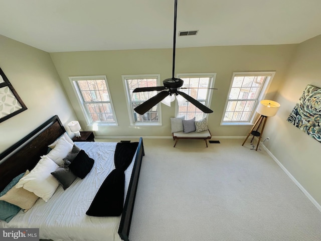 bedroom featuring carpet floors, baseboards, multiple windows, and visible vents