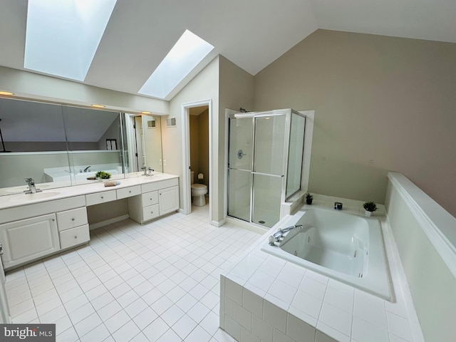 bathroom featuring toilet, vanity, lofted ceiling with skylight, a tub with jets, and a stall shower