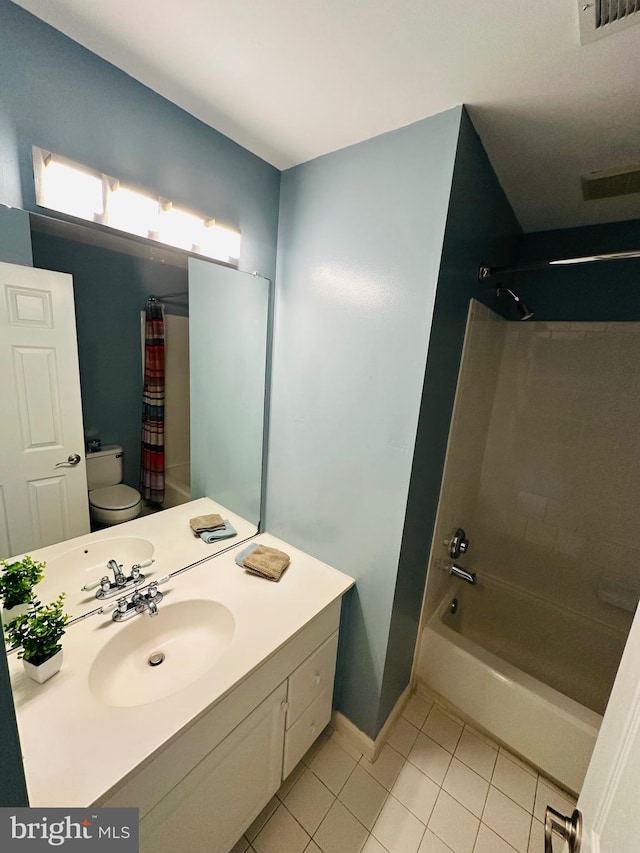 bathroom featuring toilet, vanity, baseboards, tile patterned floors, and shower / bath combo