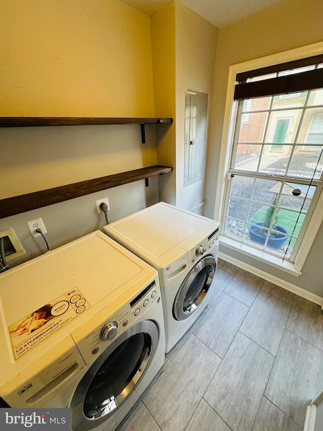 washroom featuring laundry area, washer and clothes dryer, electric panel, and baseboards