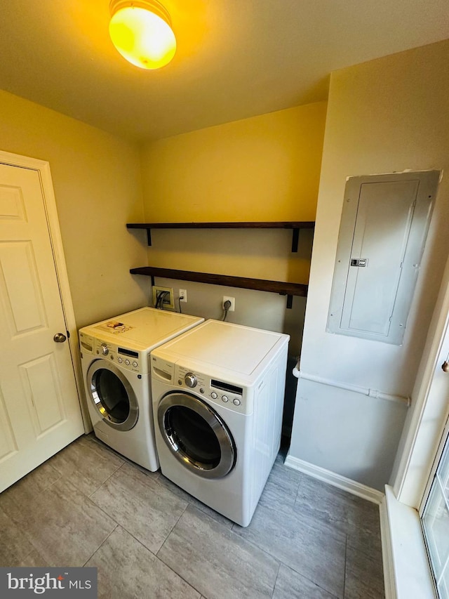 washroom featuring laundry area, electric panel, and washer and clothes dryer