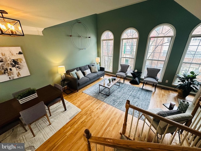 living room featuring lofted ceiling, wood finished floors, and an inviting chandelier