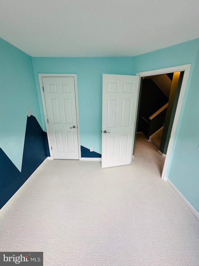 unfurnished bedroom featuring carpet floors and baseboards