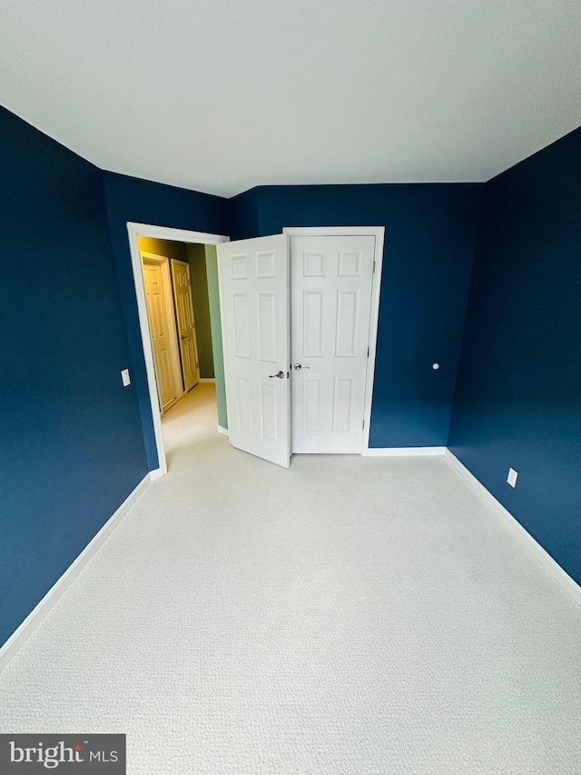 unfurnished bedroom featuring carpet and baseboards