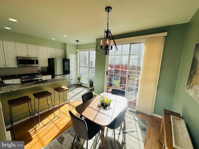 dining space featuring recessed lighting, visible vents, baseboards, light wood finished floors, and an inviting chandelier