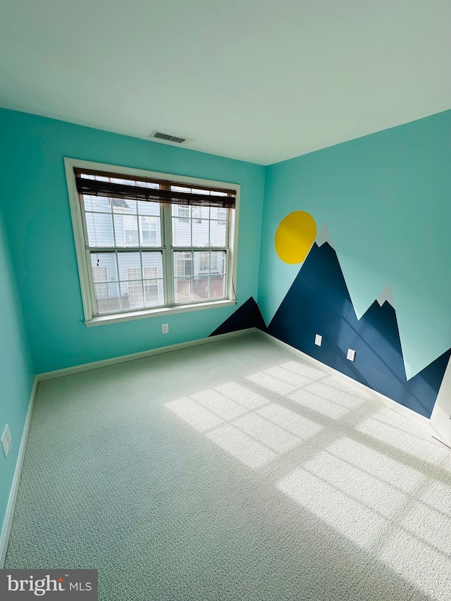 spare room featuring carpet flooring, visible vents, and baseboards