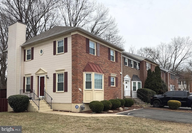 view of front facade featuring a chimney and a front lawn