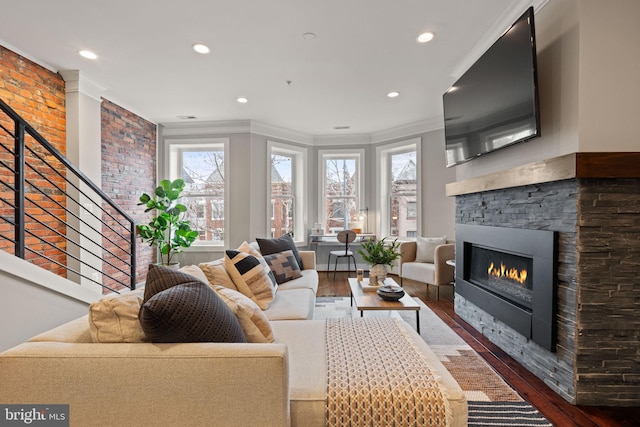 living area featuring dark wood-type flooring, recessed lighting, a fireplace, and crown molding