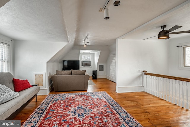 living room featuring hardwood / wood-style flooring, a textured ceiling, and rail lighting