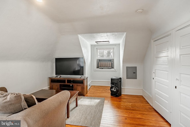 living room with electric panel, wood-type flooring, and lofted ceiling