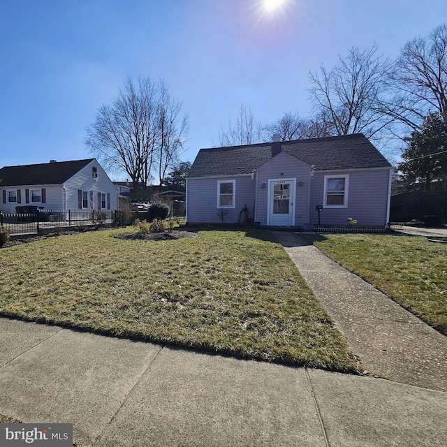 view of front of home with fence and a front lawn