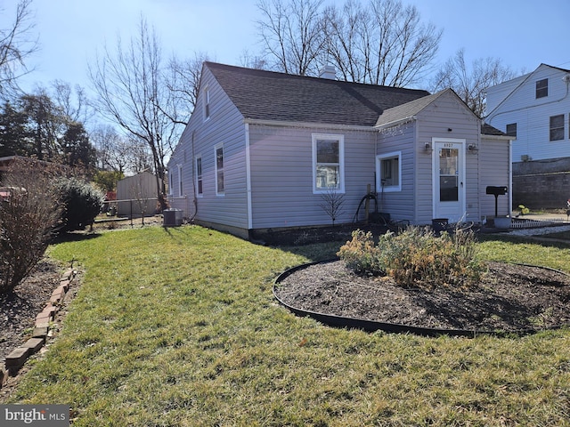 view of front of home featuring central AC and a front yard