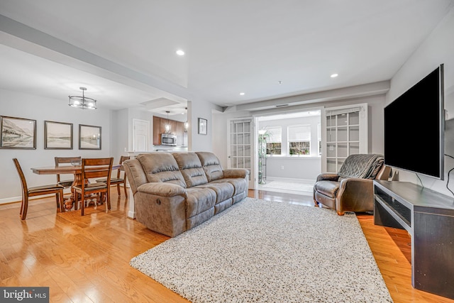 living room featuring recessed lighting, light wood-style flooring, and baseboards