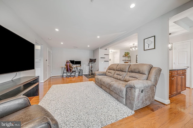 living area with baseboards, recessed lighting, and light wood-style floors