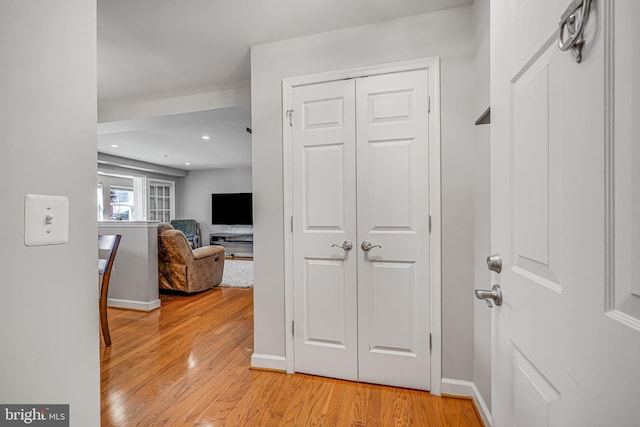 hall with light wood finished floors, baseboards, and recessed lighting