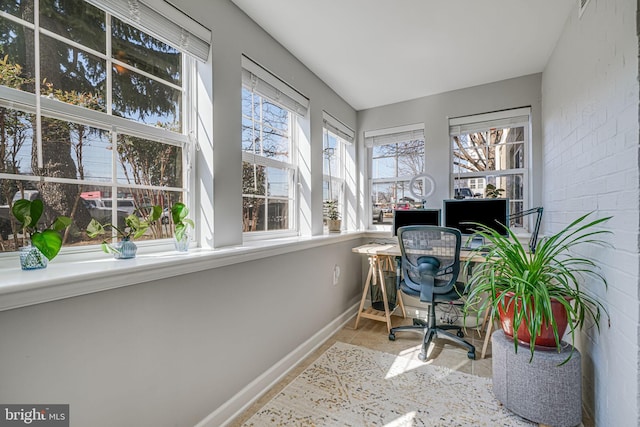 office area with brick wall and baseboards