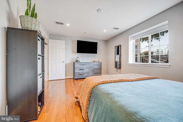 bedroom with baseboards, light wood-type flooring, visible vents, and recessed lighting