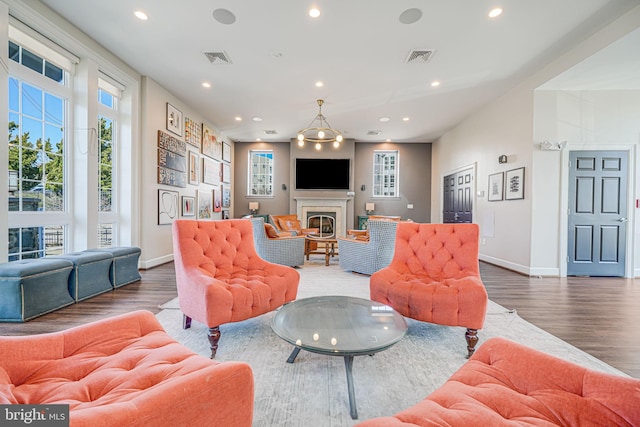 living room with recessed lighting, baseboards, wood finished floors, and a glass covered fireplace