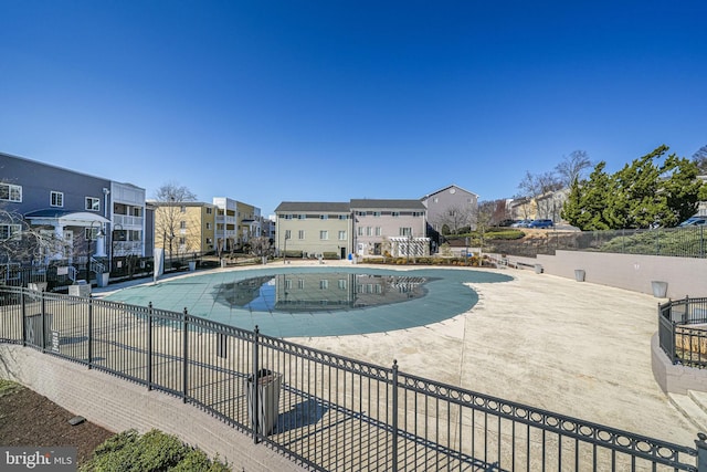 pool featuring a residential view, a patio area, and fence