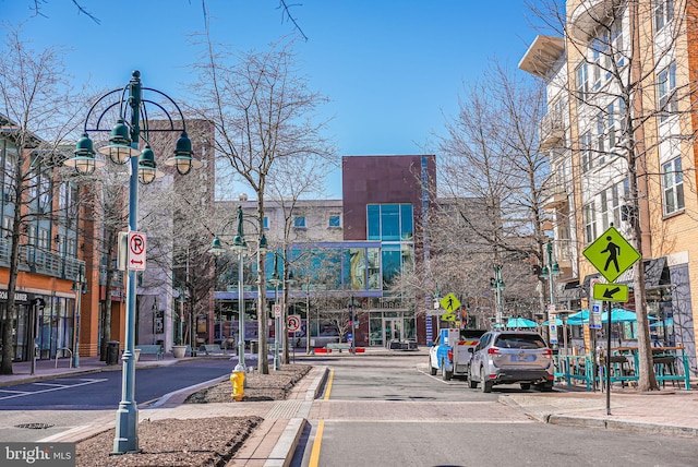 view of street featuring sidewalks, traffic signs, curbs, and street lights