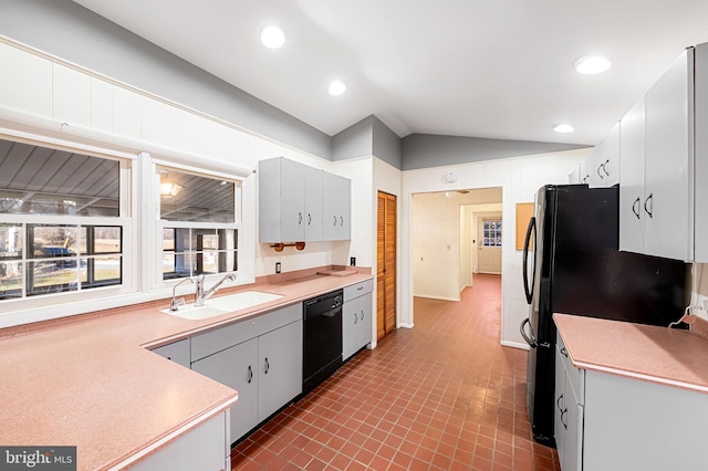 kitchen featuring vaulted ceiling, sink, and black appliances